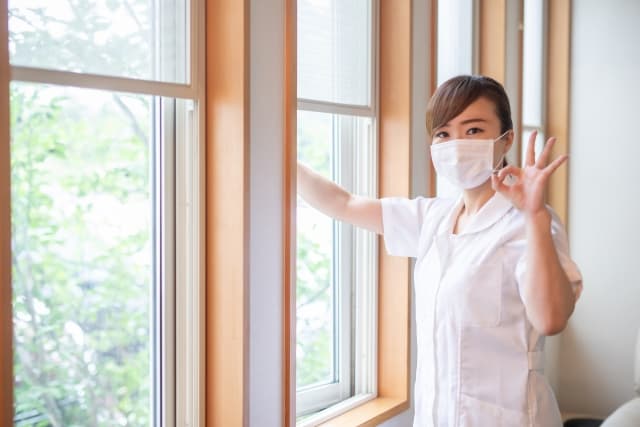 窓を開けて換気する看護師